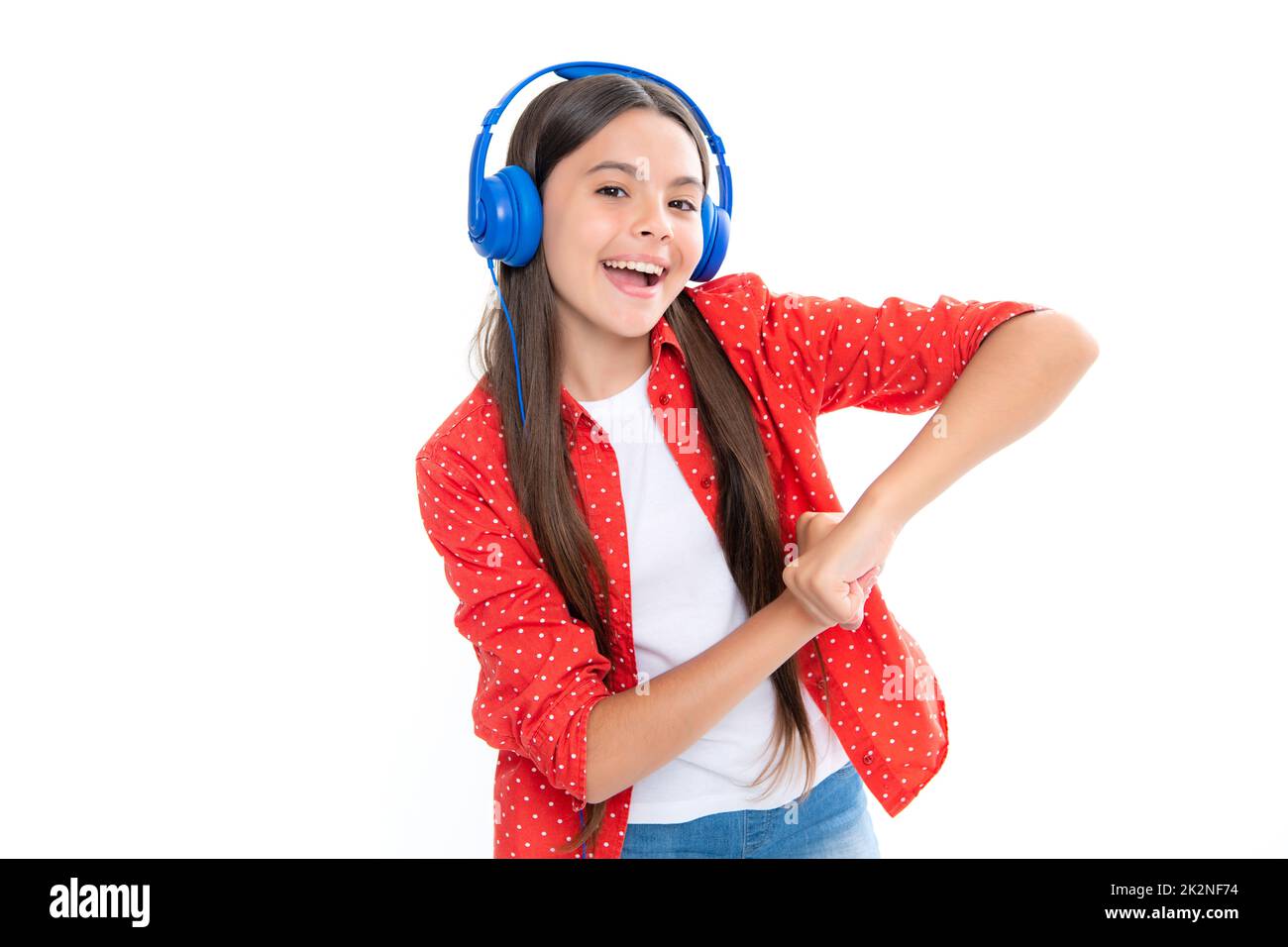 Funny kid girl 12, 13, 14 years old listen music with headphones. Teenage girl with headphones listening songs on headset earphone. Portrait of happy Stock Photo