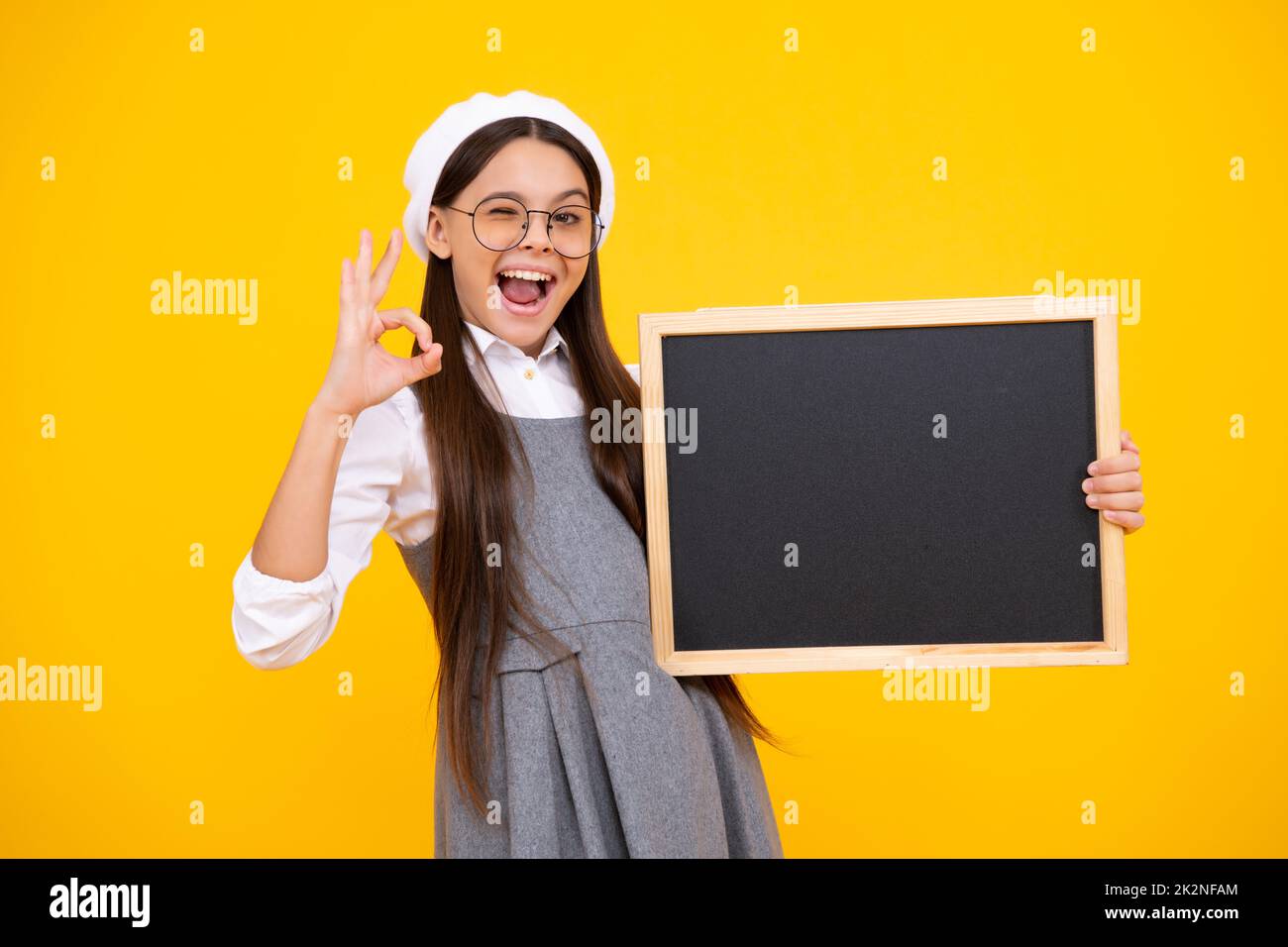 School sales board. Cheerful teenage girl kid hold blackboard chalkboard with copy space. Excited teenager girl. Stock Photo