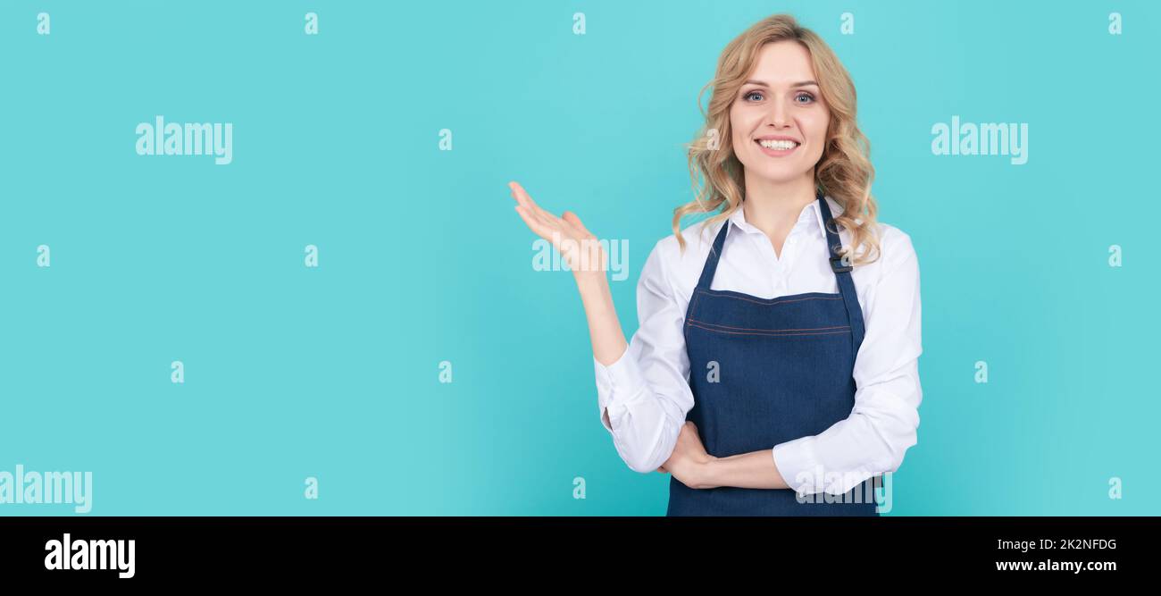 happy woman barista in chef apron presenting product, household. Woman isolated face portrait, banner with mock up copy space. Stock Photo