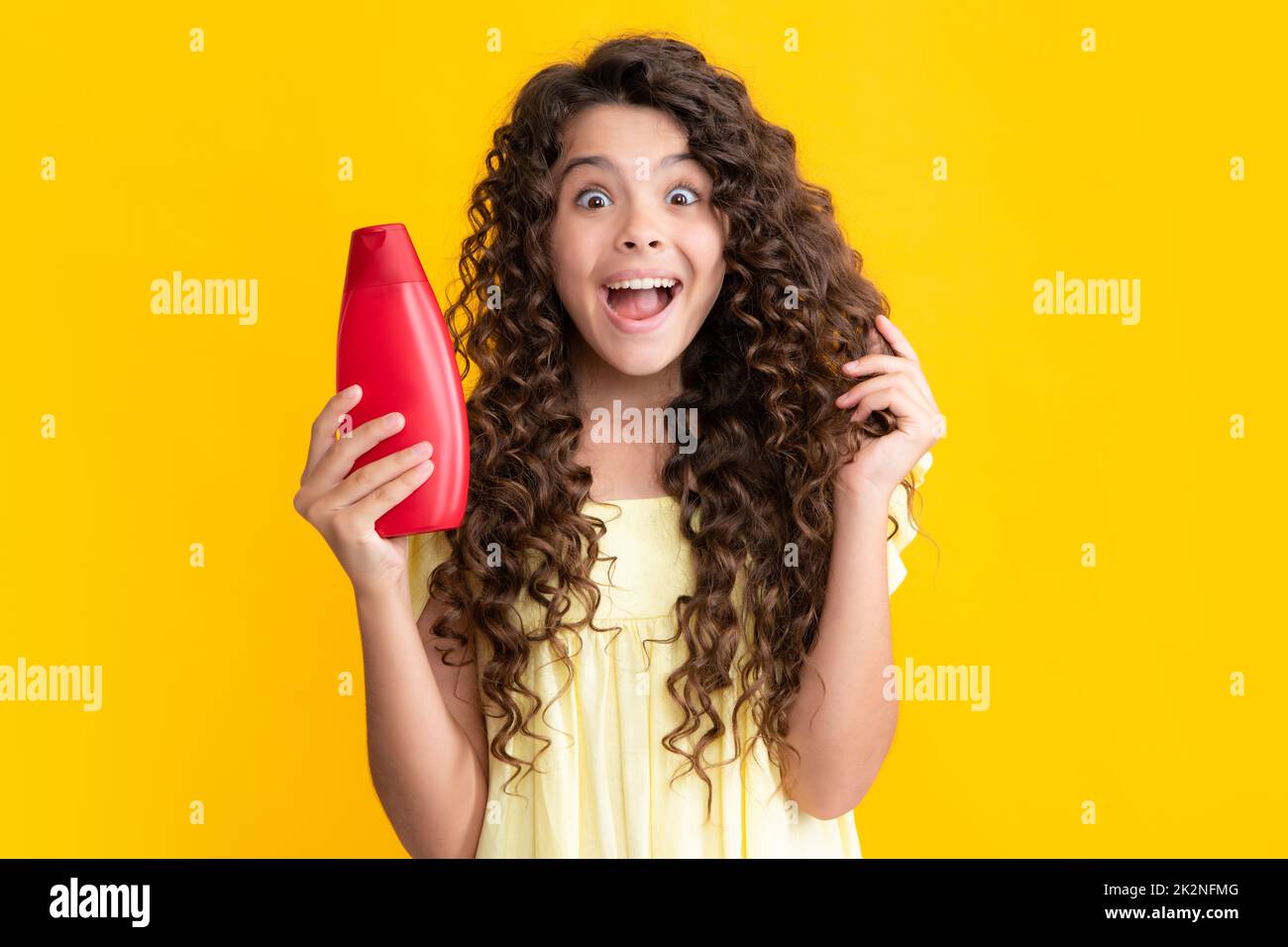 Teenage girl with shampoos conditioners or shower gel. Kids hair care cosmetic product, shampoo bottle. Excited teenager, glad amazed and overjoyed Stock Photo