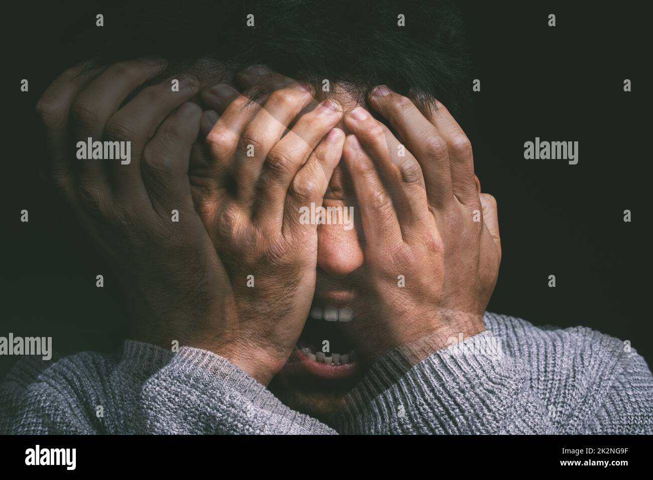 When your mind is your own worst enemy. Studio shot of a young man experiencing mental anguish and screaming against a black background. Stock Photo