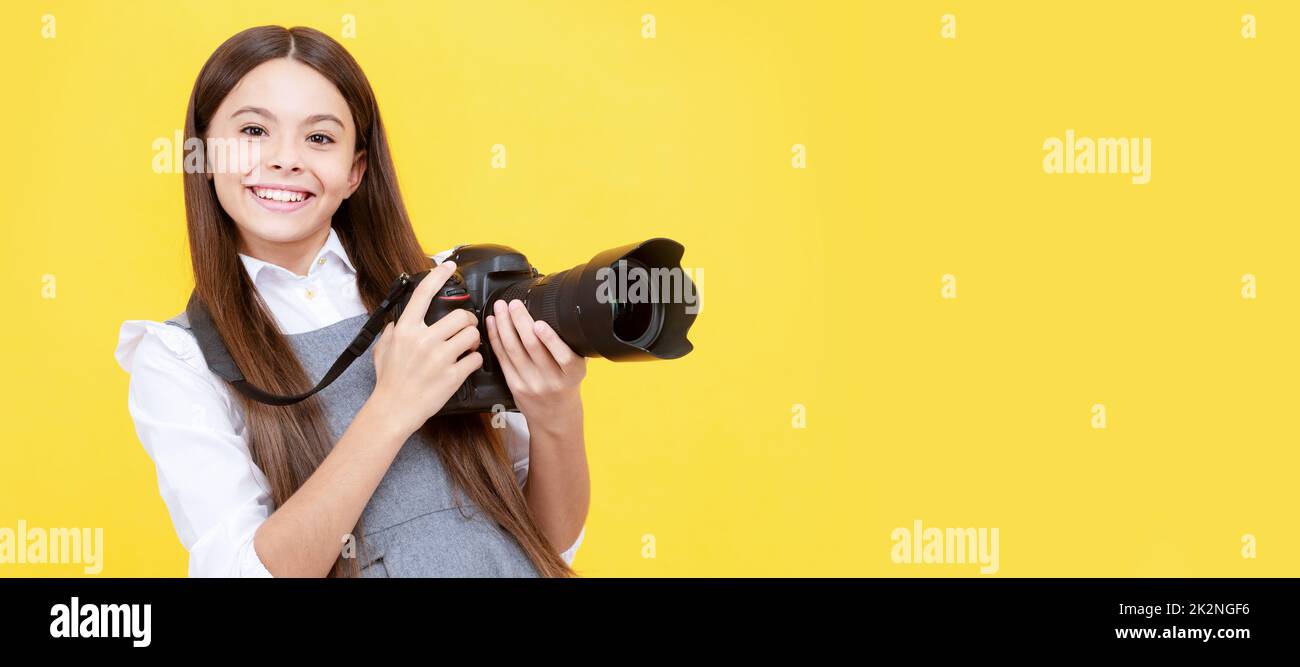 happy teen girl photographer use digital photo camera, photographing. Child photographer with camera, horizontal poster, banner with copy space. Stock Photo