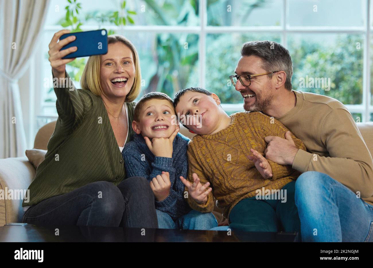Well always remember these moments. Shot of a family taking a selfie using a smartphone. Stock Photo