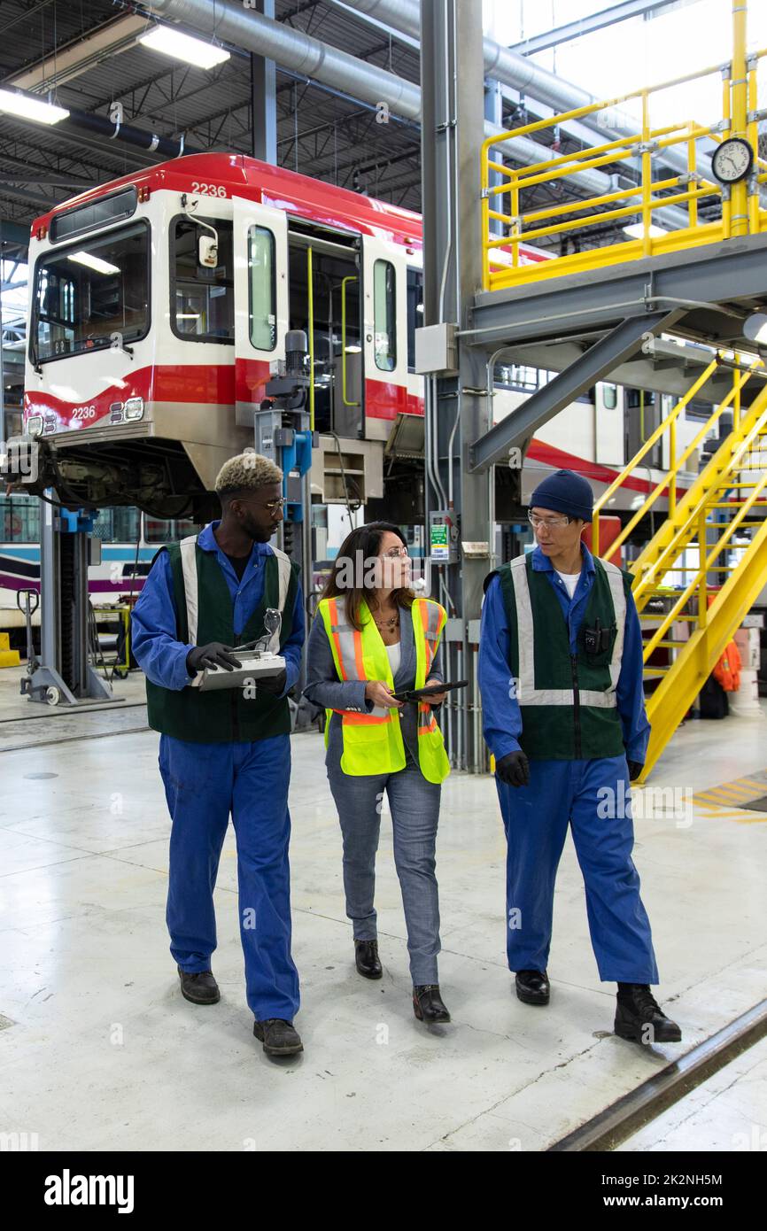 Transit workers and manager talking in maintenance facility Stock Photo