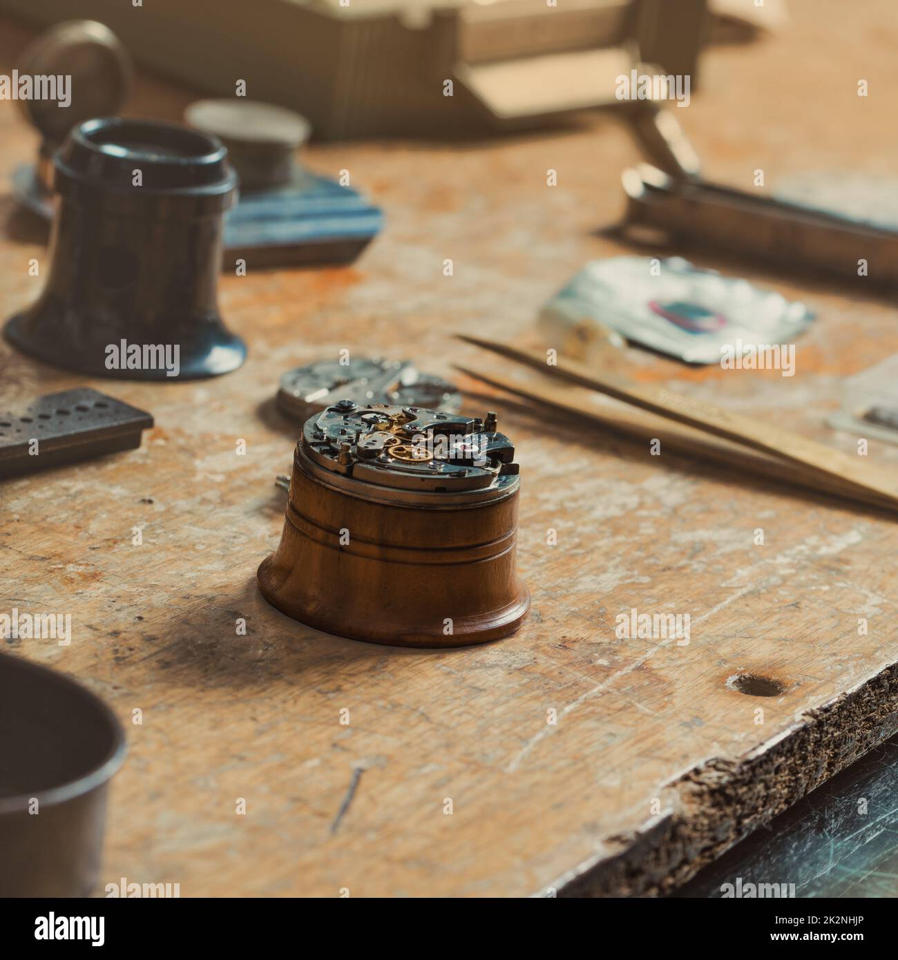 Old watch mechanism dismantled for repair on a workbench Stock Photo