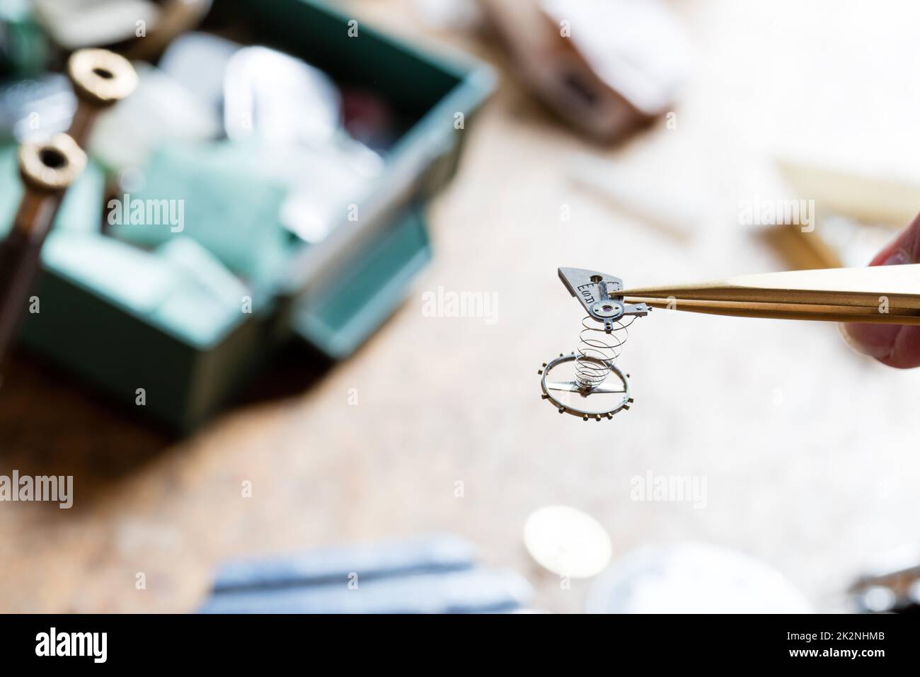 Watchmaker or clockmaker holding a watch spring in tweezers Stock Photo
