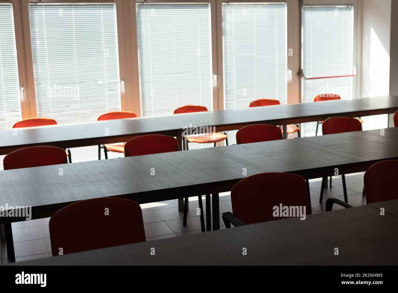 Empty desks and chairs in deserted office room Stock Photo Alamy
