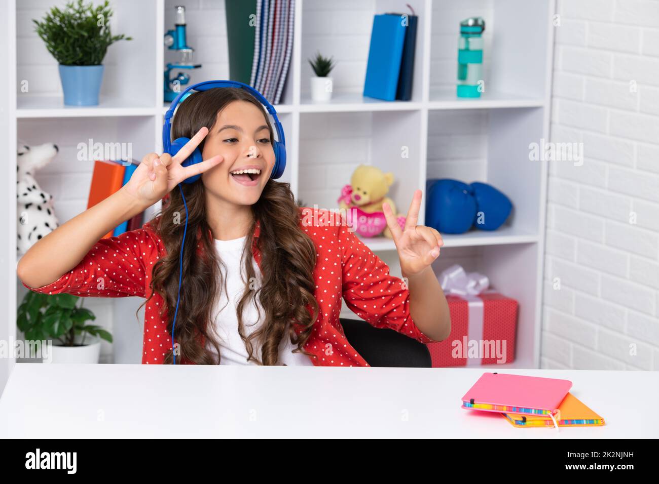 Teenager school girl listening music. Portrait of teen with headphone. Children, music, emotions concept. Excited schoolgirl. Happy girl face Stock Photo