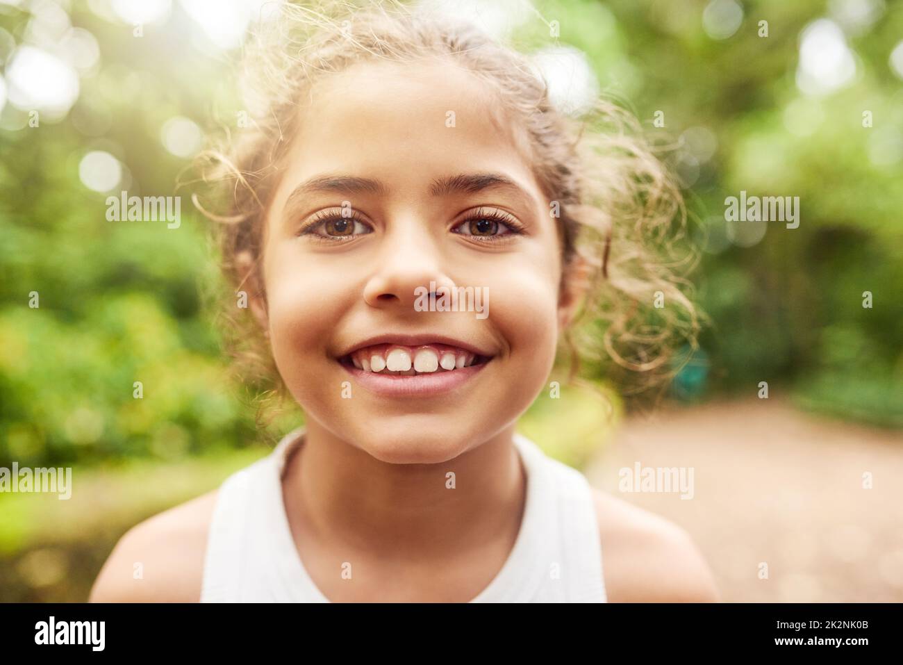 I love being in the park. Cropped portrait of an adorable little girl standing outside in the park. Stock Photo