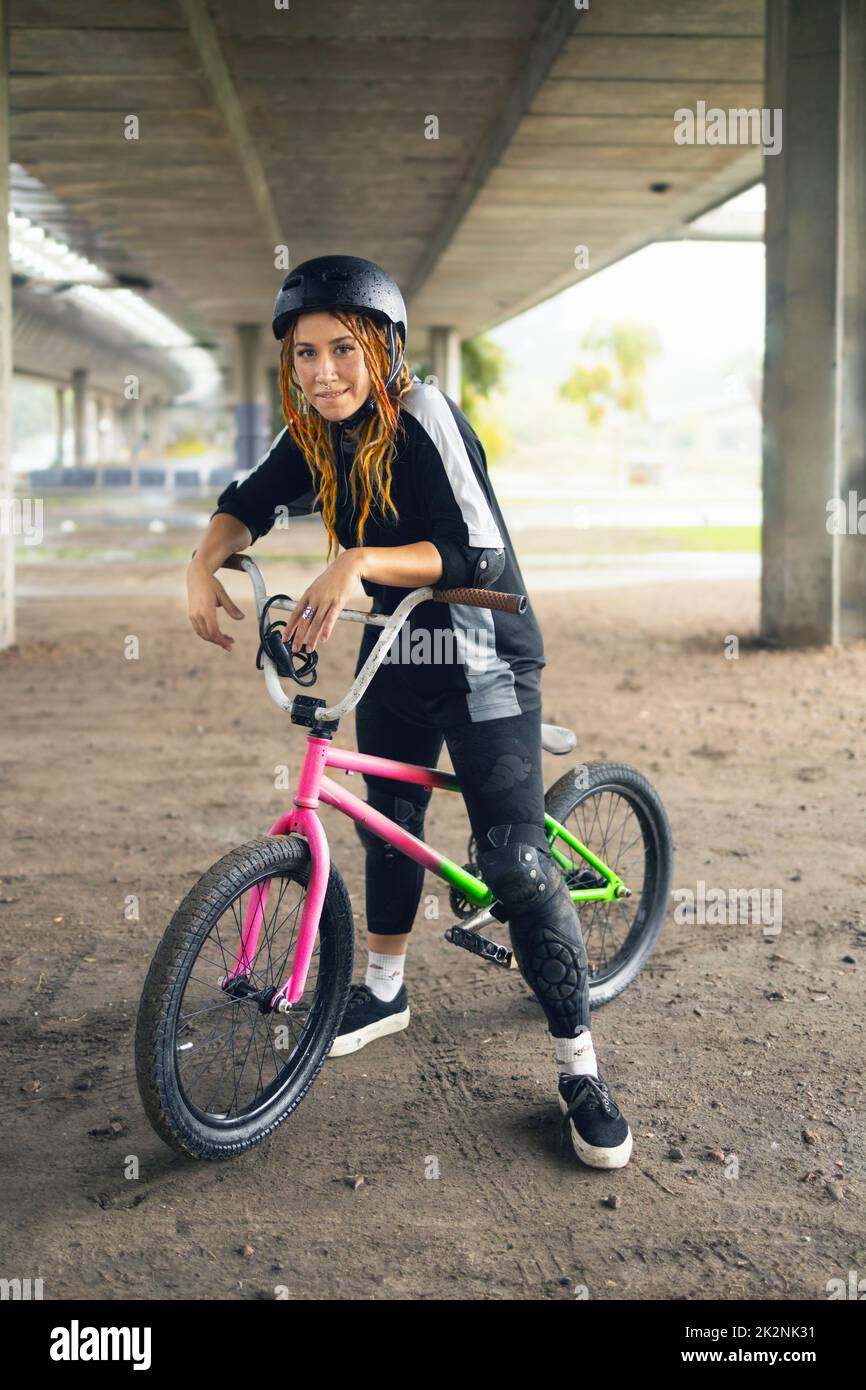 Young urban woman with freestyle bike wearing helmet Stock Photo