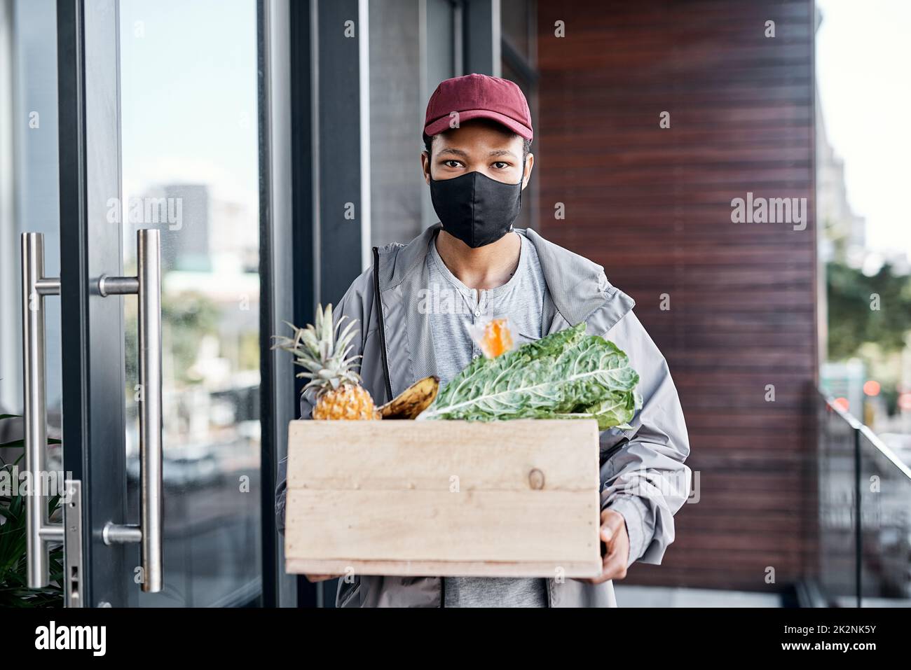 Knock, knock. Your groceries are here. Shot of a young man delivering