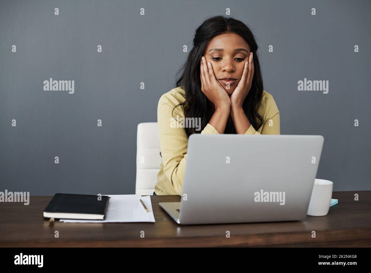 I need a jolt of excitement in my life. Shot of a young businesswoman looking bored at her desk. Stock Photo