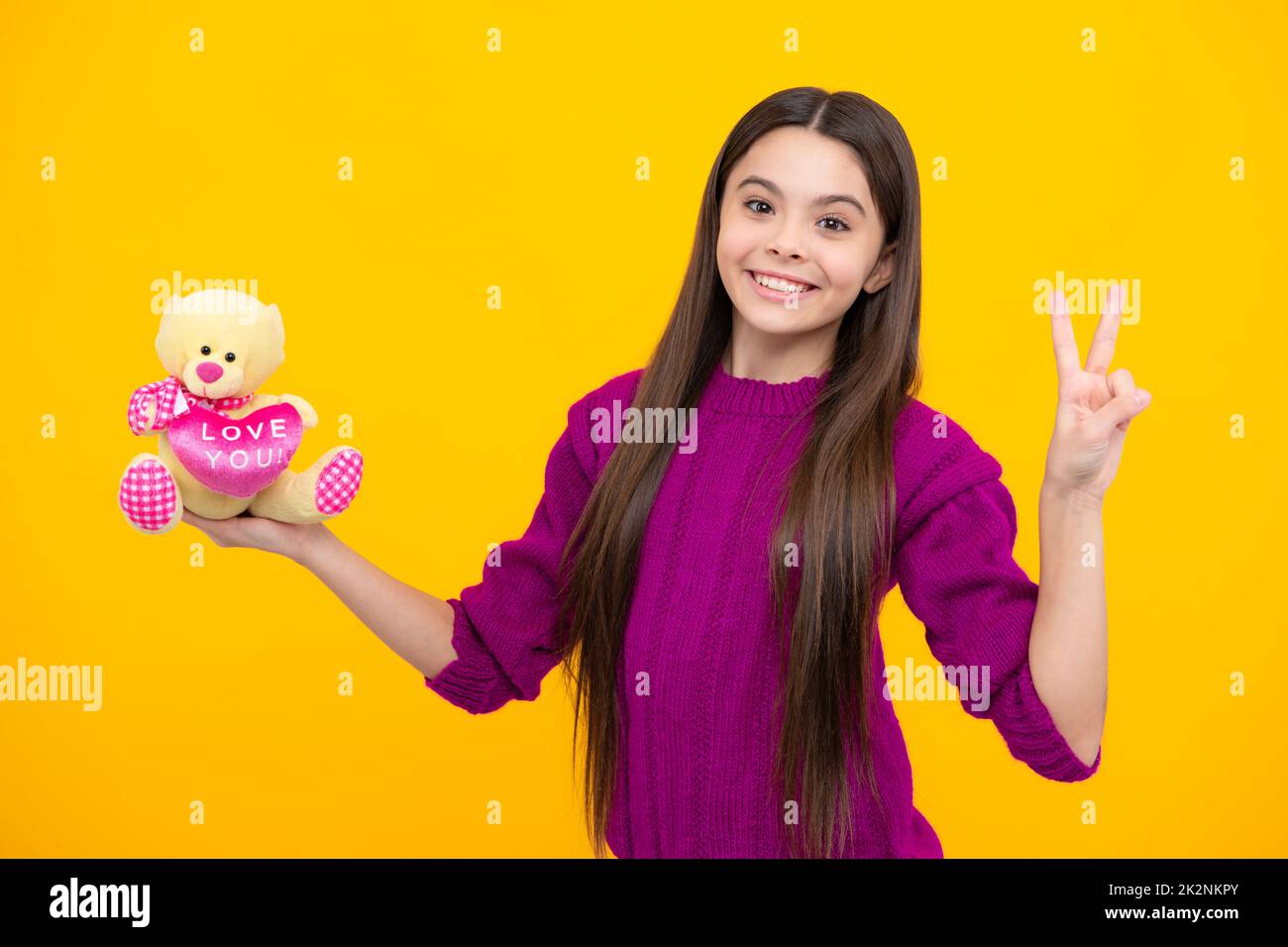 Cheerful teen child hold toy. Happy childhood. Kid playing toy. Teen with toy teddy bear with love heart for valentines day. Childcare concept. Stock Photo