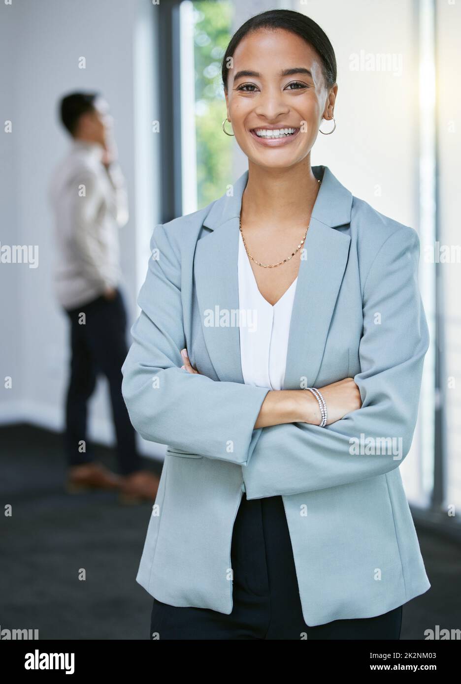 I aim to meet you every real estate need. Shot of a young businesswoman standing in a house with her arms crossed. Stock Photo