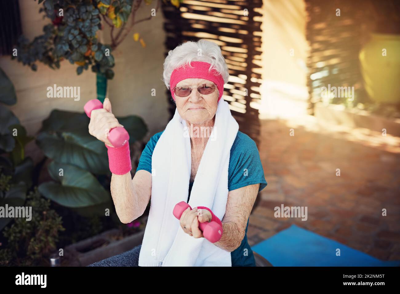 Lifting has no age restriction. Shot of a senior woman exercising at home. Stock Photo