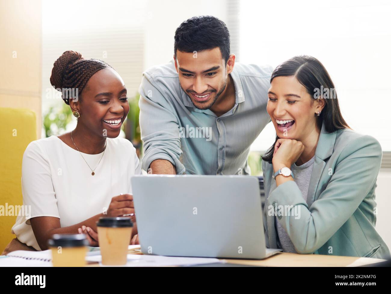 This is what youre looking for. Cropped shot of a handsome young businessman helping two female colleagues with their laptop while working in the office. Stock Photo