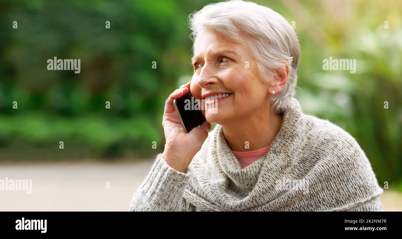 I got this thing to work. Cropped shot of a cheerful elderly woman talking on her cellphone outside in a park. Stock Photo