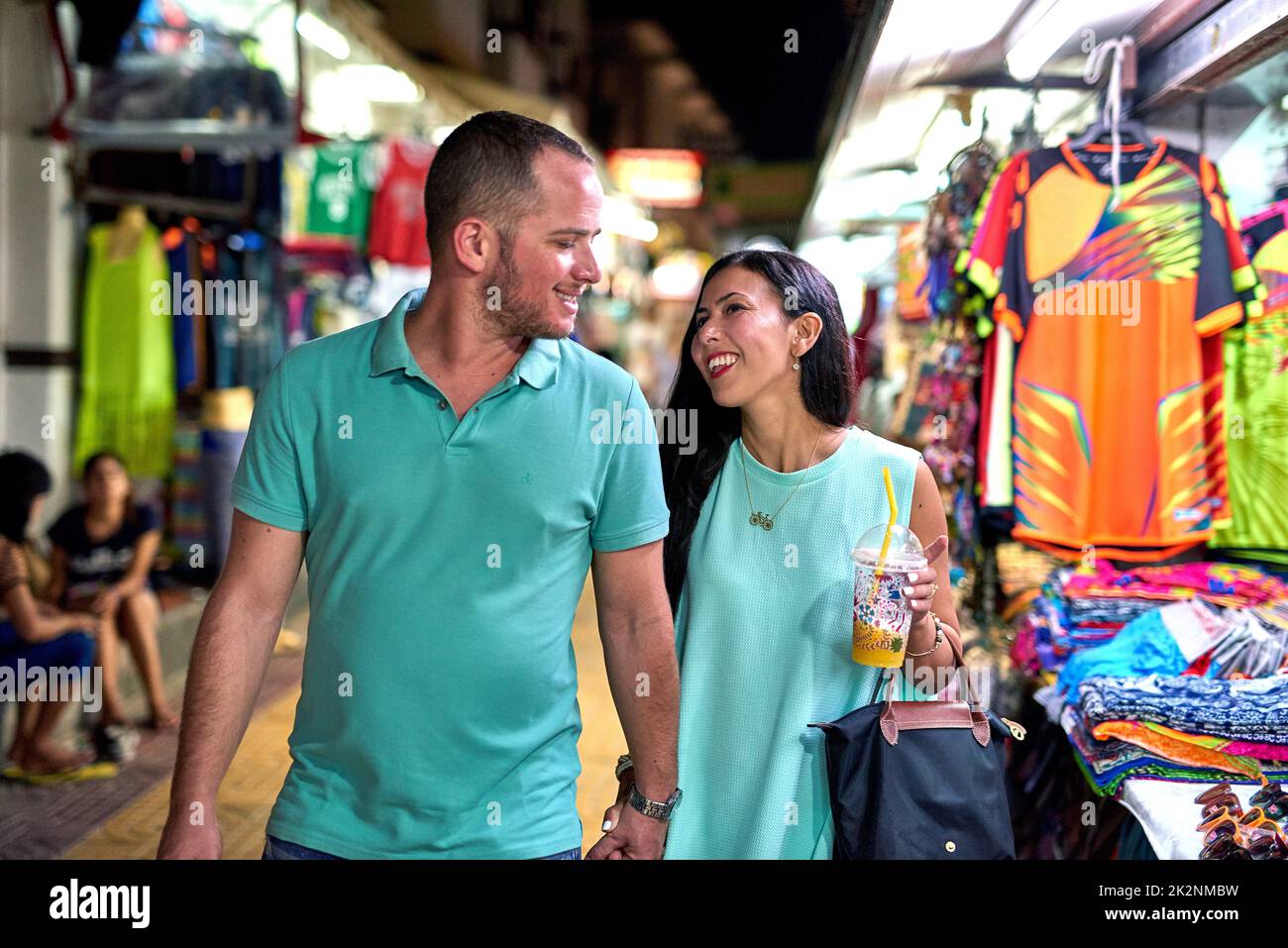 Are you having fun. Shot of a happy couple walking hand in hand Stock