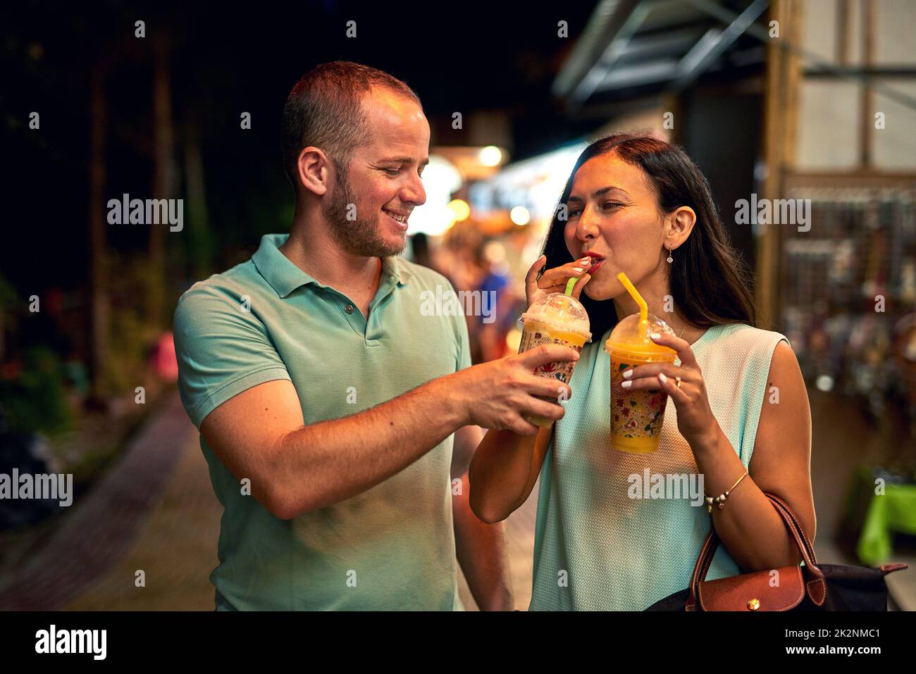 I like yours more. Shot of a woman tasting her husbands smoothie. Stock Photo