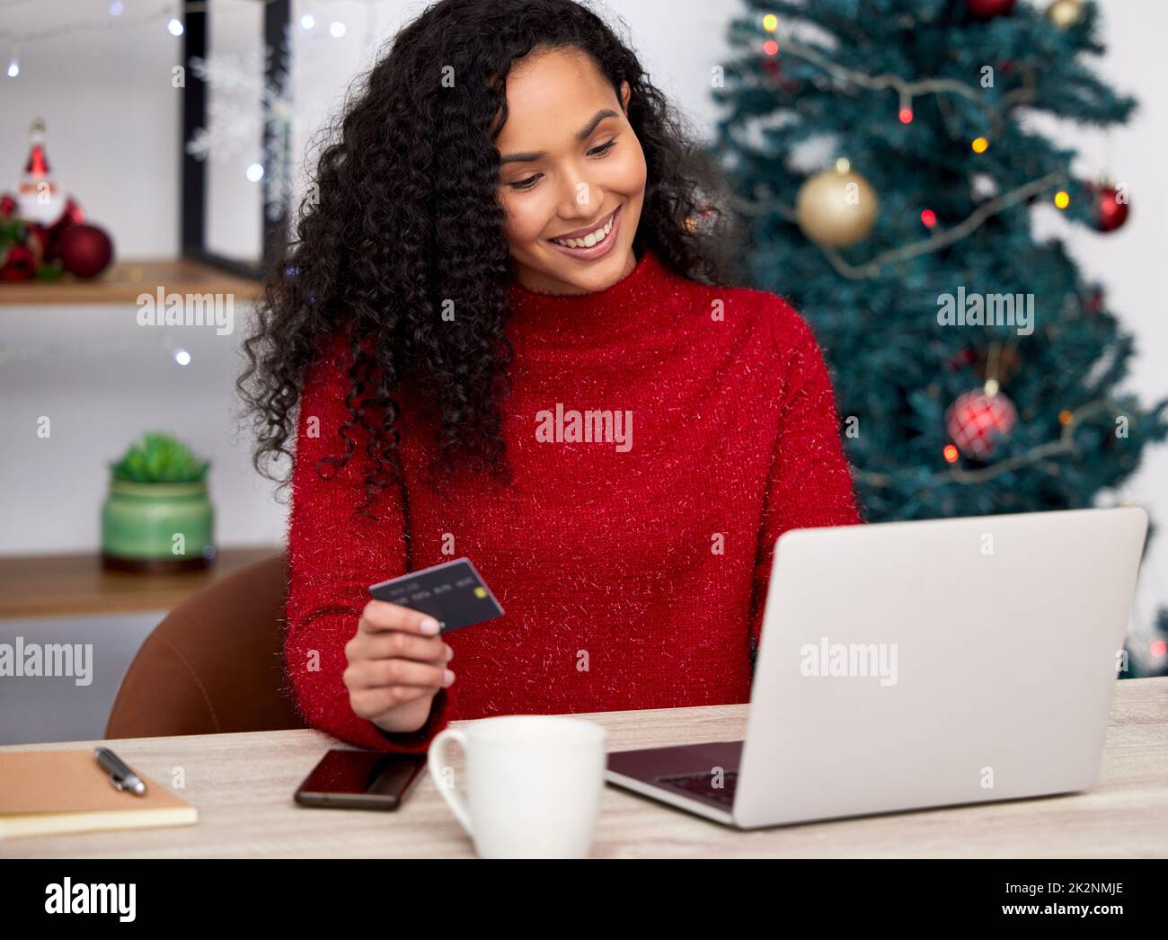The way you spend Christmas is far more important than how much. Shot of a young woman shopping online at home. Stock Photo