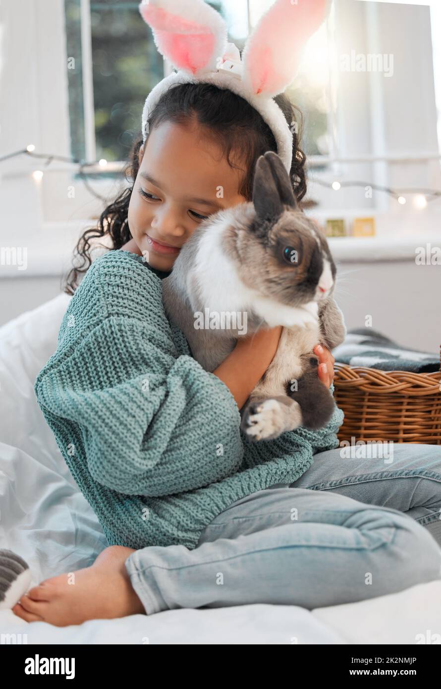 You are so loved. Shot of an adorable little girl bonding with her pet rabbit at home. Stock Photo
