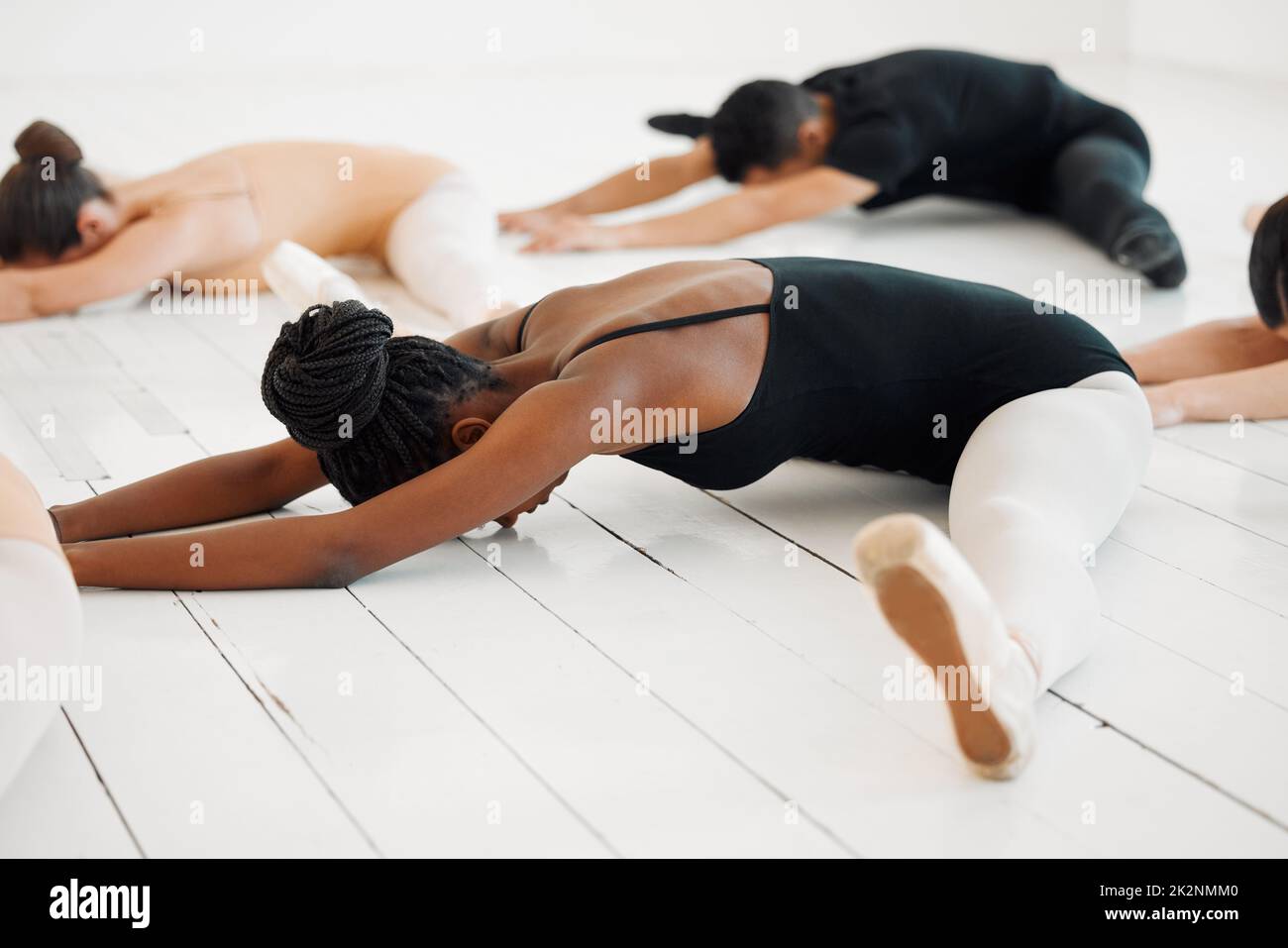 His or her body will be the music. Shot of a young group of ballerinas stretching in a dance studio. Stock Photo