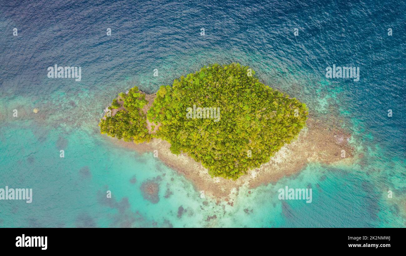A quiet little islet. High angle shot of a little islet in the middle of the wonderful Raja Ampat Islands in Indonesia. Stock Photo