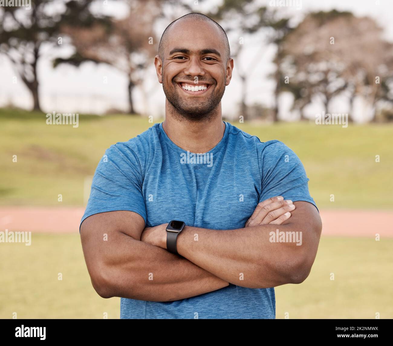 Staying fit is a lifestyle I choose. Shot of a handsome young man standing alone outside with his arms folded before playing sports. Stock Photo
