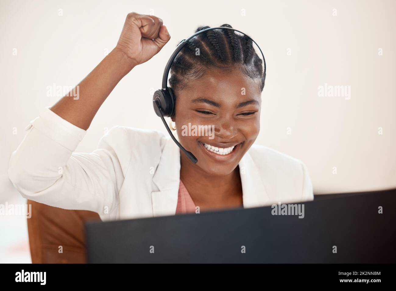 Ill earn extra commission on this one. Shot of a young call centre agent cheering while working on a computer in an office. Stock Photo