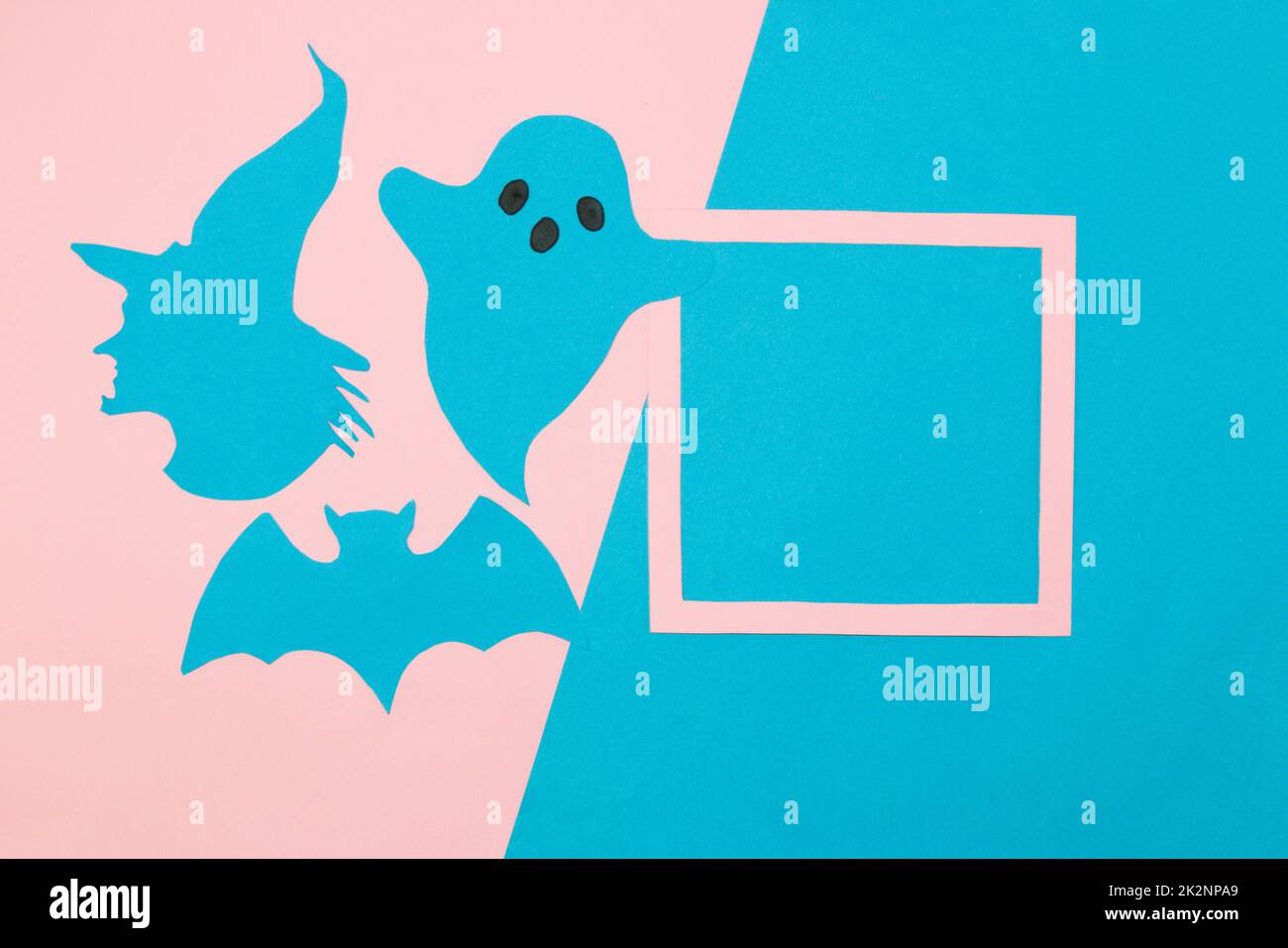 witch head, ghost and bat next to frame as copy space, pink-blue background, creative halloween concept, flat lay, paper craft Stock Photo