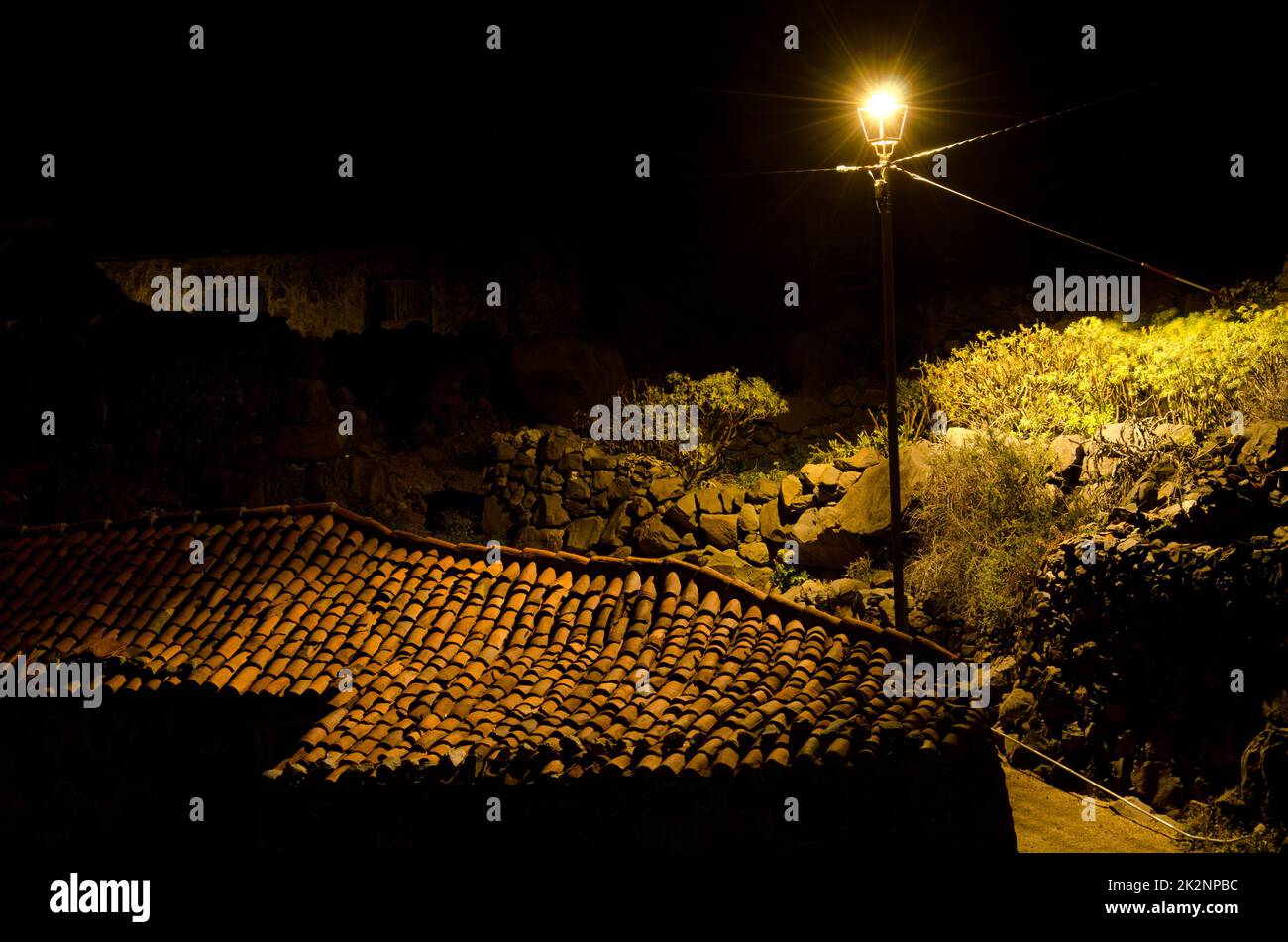 Streetlight illuminating the roof of a house. Stock Photo