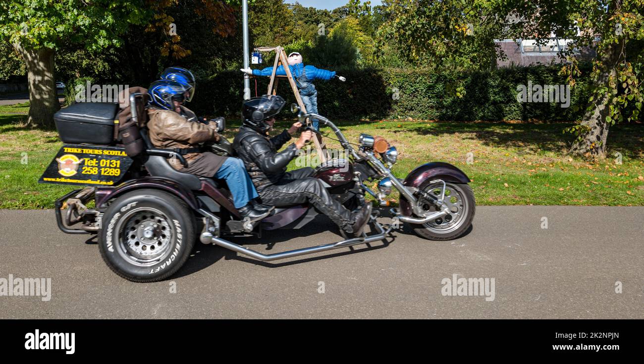 Dirleton, East Lothian, Scotland, UK, 23rd September 2022. Scarecrow Trail: the second trail this year has 18 scarecrows around the village. Pictured: a fabulous scarecrow on the village green as a motorbike trike speeds past. Credit: Sally Anderson/Alamy Live News Stock Photo