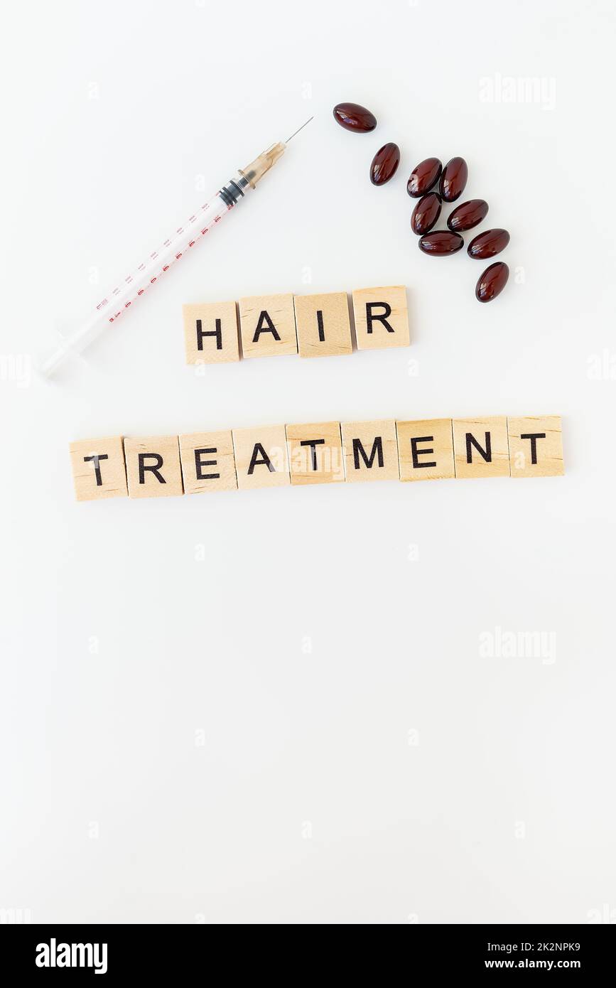 Inscription hair treatment, syringe for hair vitamin injection. The concept of hair treatment, regeneration and volumizing for hair. Stock Photo