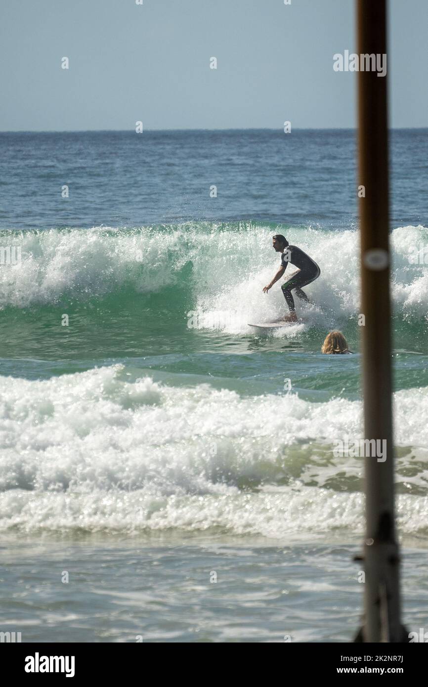 A vertical shot of surfer riding surfboard in ocean Stock Photo Alamy