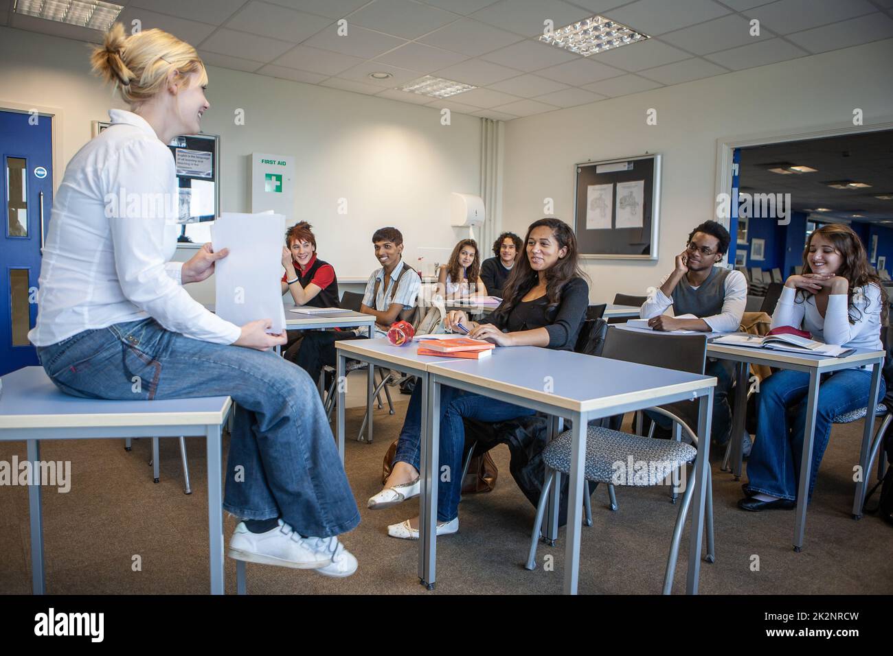 Teenage Students: Classroom. A teacher in a relaxed and informal mood with her attentive and inspired class. From a series of related images. Stock Photo