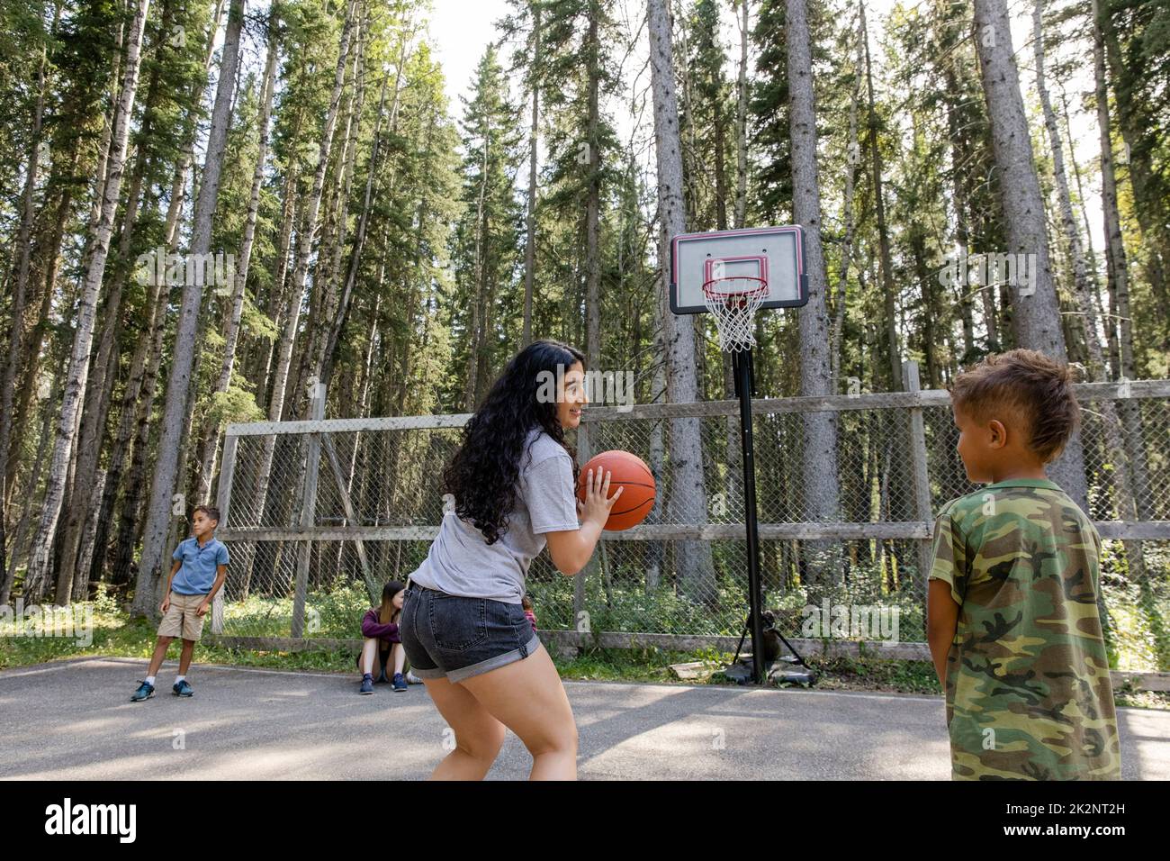 Camp counselor teaching boys basketball at summer camp Stock Photo Alamy