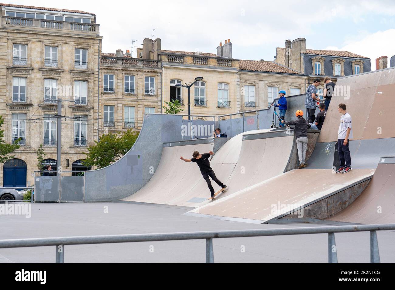 An inline roller blader performing jumps at a local skate park in