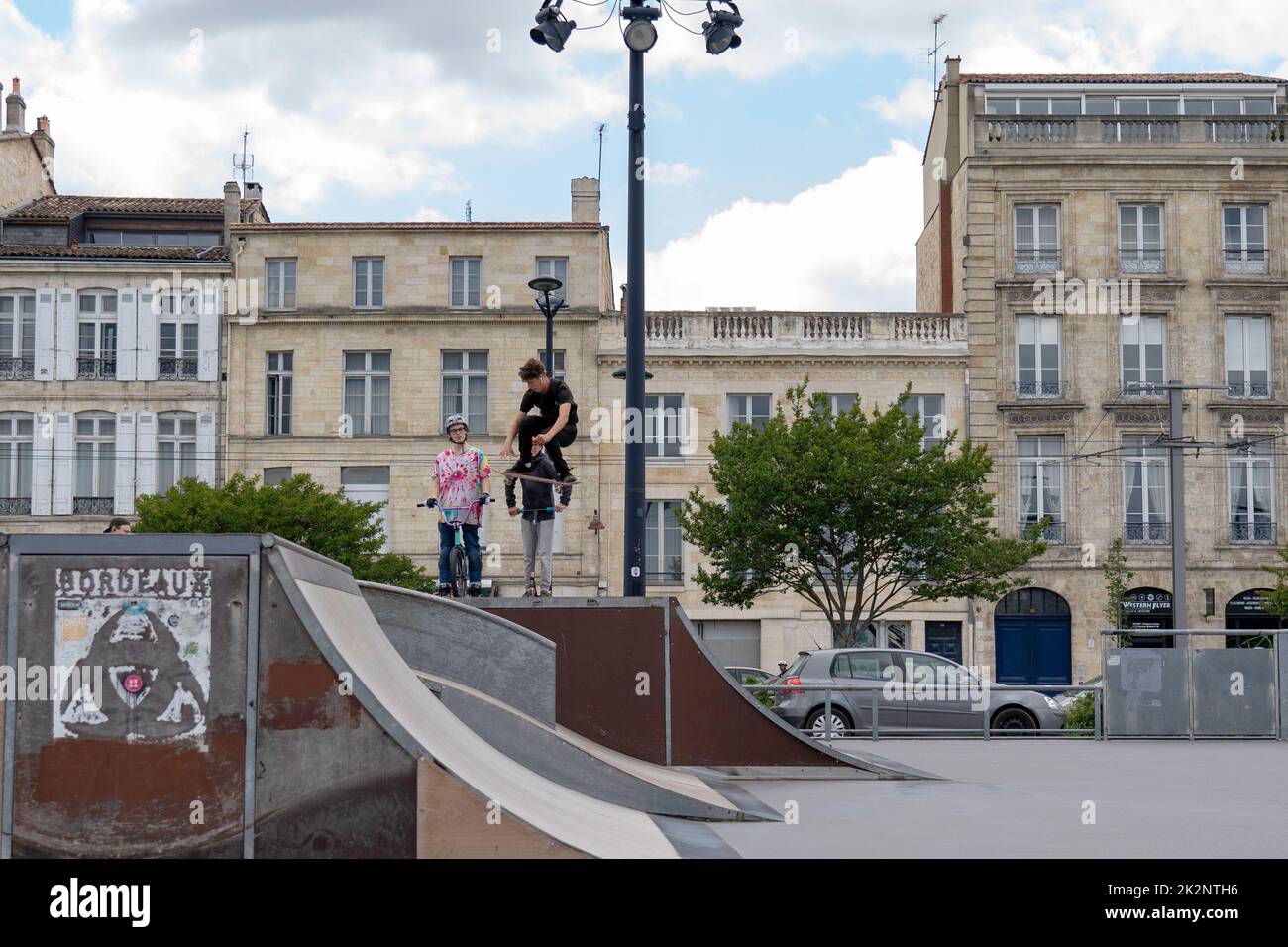 An inline roller blader performing jumps at a local skate park in