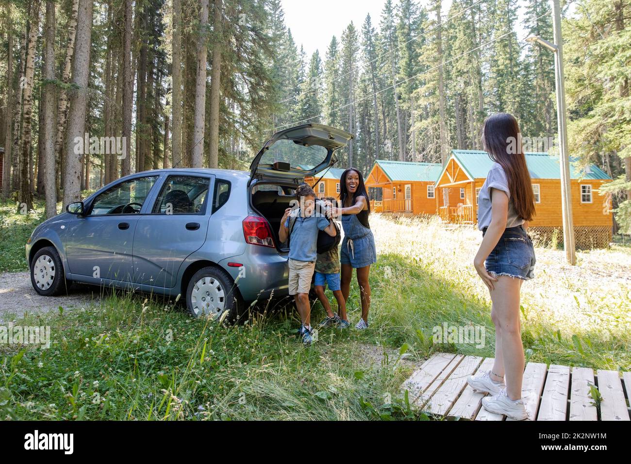 Camp counselor welcoming family to summer camp Stock Photo