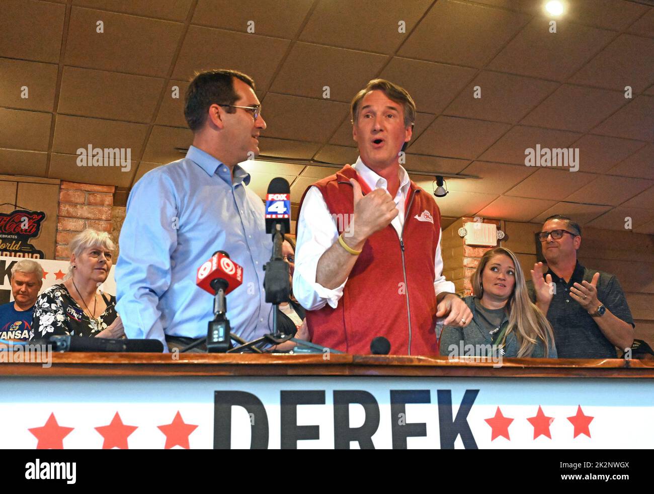 Shawnee, KS, USA. 22nd Sep, 2022. Kansas Attorney General Derek Schmidt (L) current Republican gubernatorial candidate listens as Virginia Governor Glenn Youngkin addresses supporters during a fundraiser rally at HaywardÕs Pit Bar B Que restaurant to support Schmidt in a tight race against incumbent Governor Laura Kelly Shawnee, Kansas on September 22, 2022. Credit: Mark Reinstein/Media Punch/Alamy Live News Stock Photo