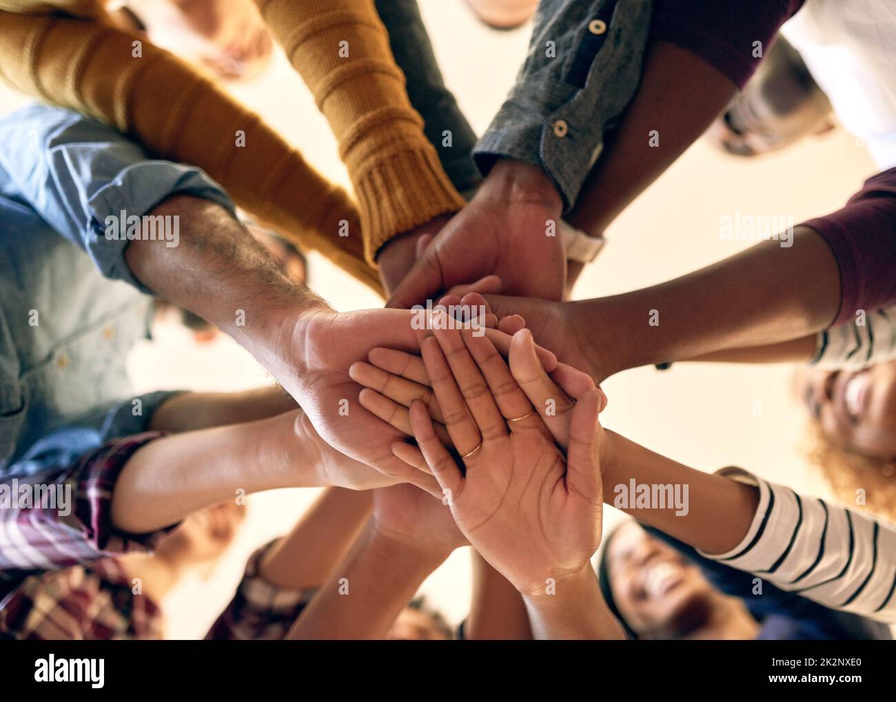 Joining their strengths in unity. Low angle shot of a group of people joining their hands together. Stock Photo