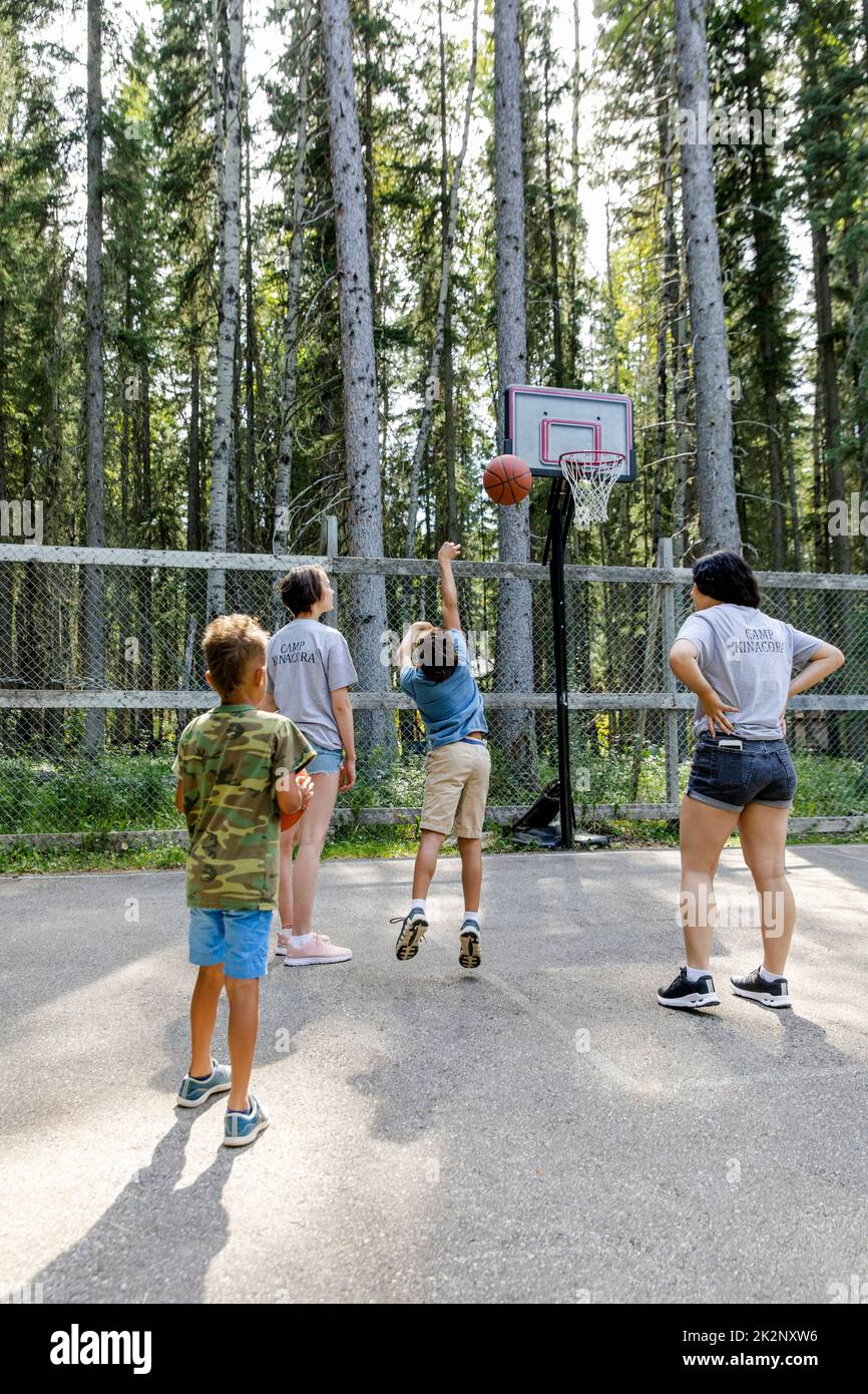 Camp counselors teaching boys basketball at summer camp Stock Photo Alamy