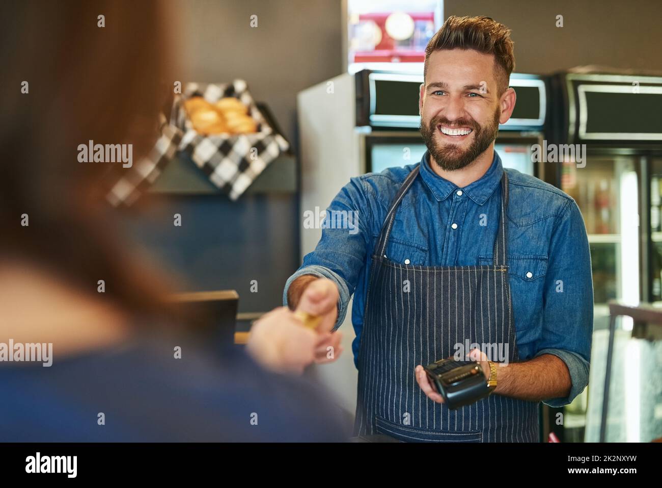 Transactions made quick and easy. Cropped shot of a waiter accepting a credit card payment from a customer. Stock Photo