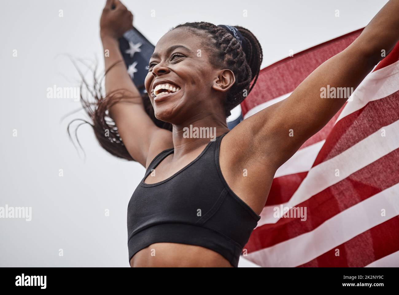The training was worth it. Shot of a young female athlete holding a flag. Stock Photo