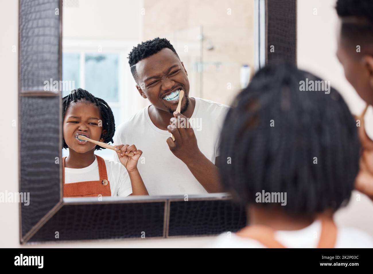Make sure you get every tooth. Shot of a young father bonding with his