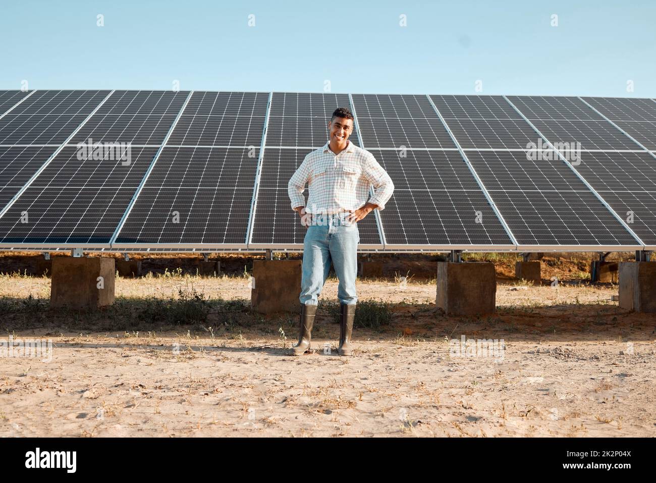 Technology making farming easier. Shot of a young man standing next to a solar panel on a farm. Stock Photo