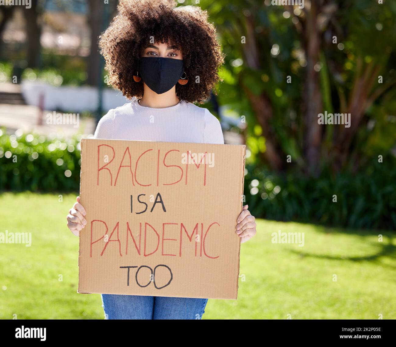 Protesting is our weapon. Shot of a unrecognizable woman protesting outside in the park. Stock Photo
