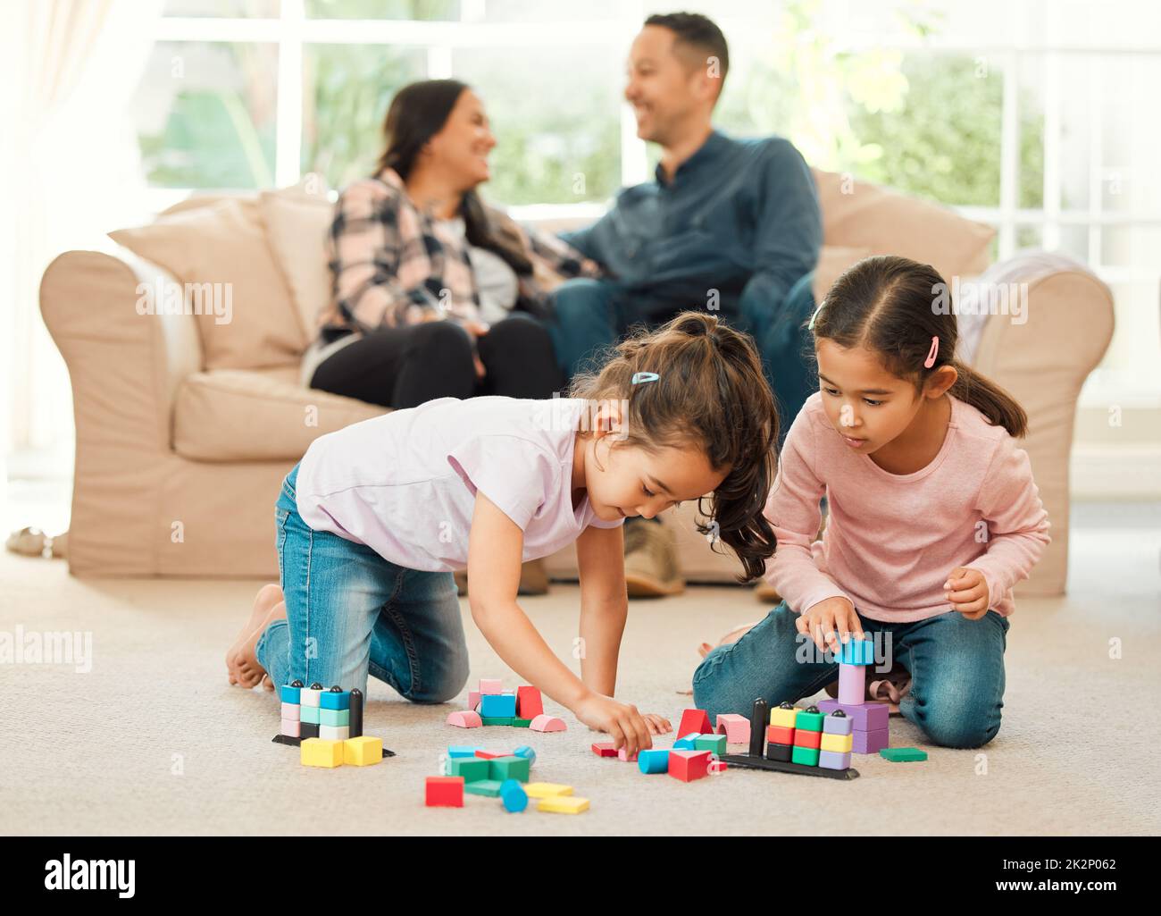We bond differently. Shot of a young family bonding inn the lounge at home. Stock Photo
