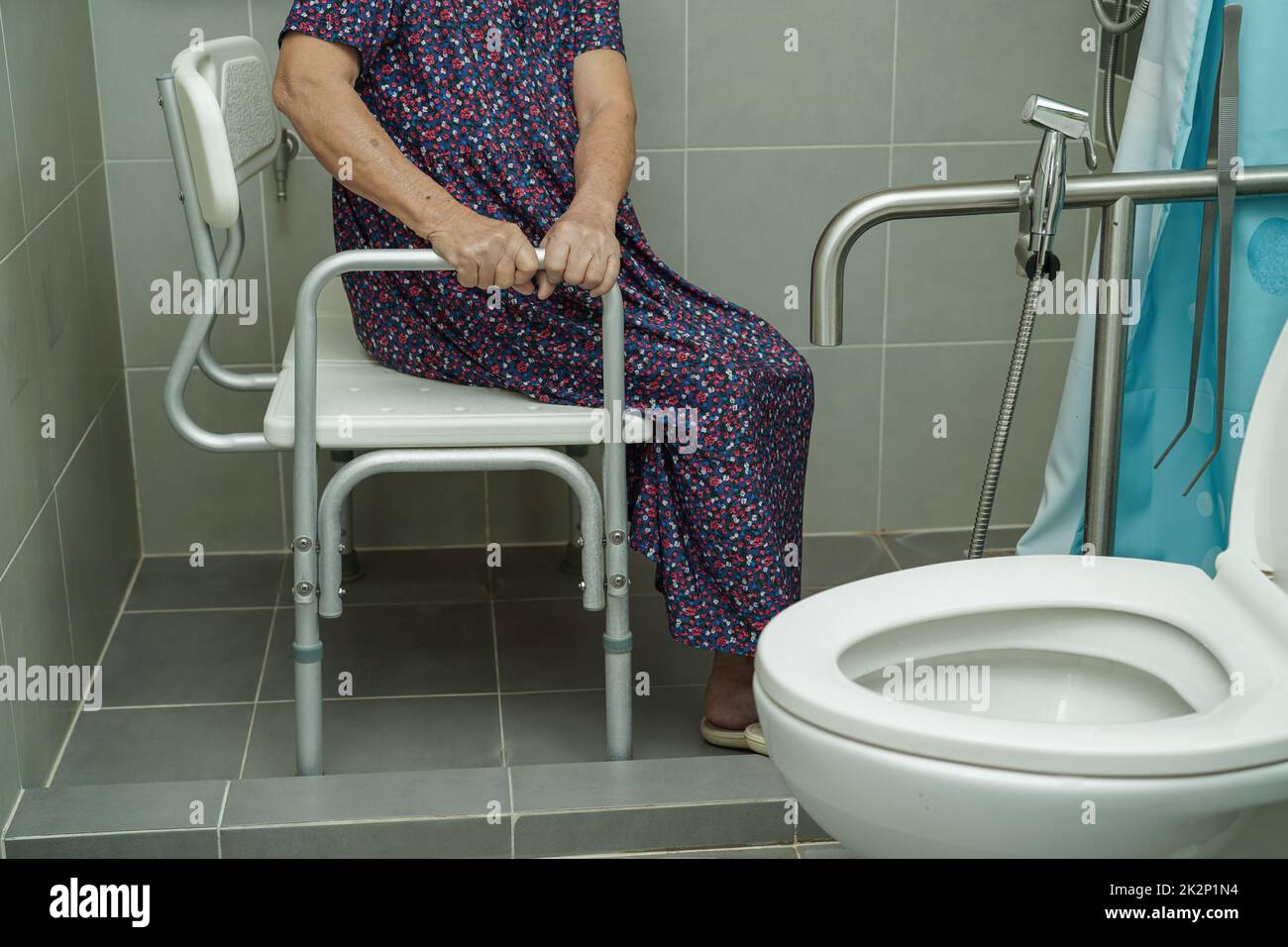 Asian elderly old woman patient use toilet support rail in bathroom, handrail safety grab bar, security in nursing hospital. Stock Photo