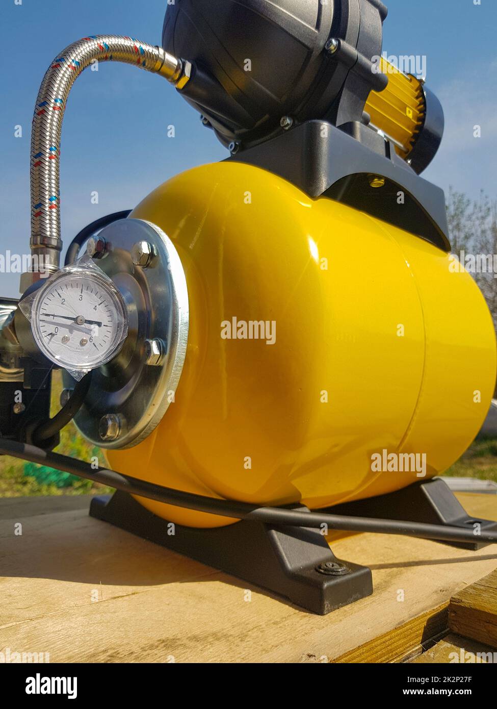 New water pumping station, household automatic station with pressure sensor, yellow color. Application of house, country house, village, cottage Stock Photo